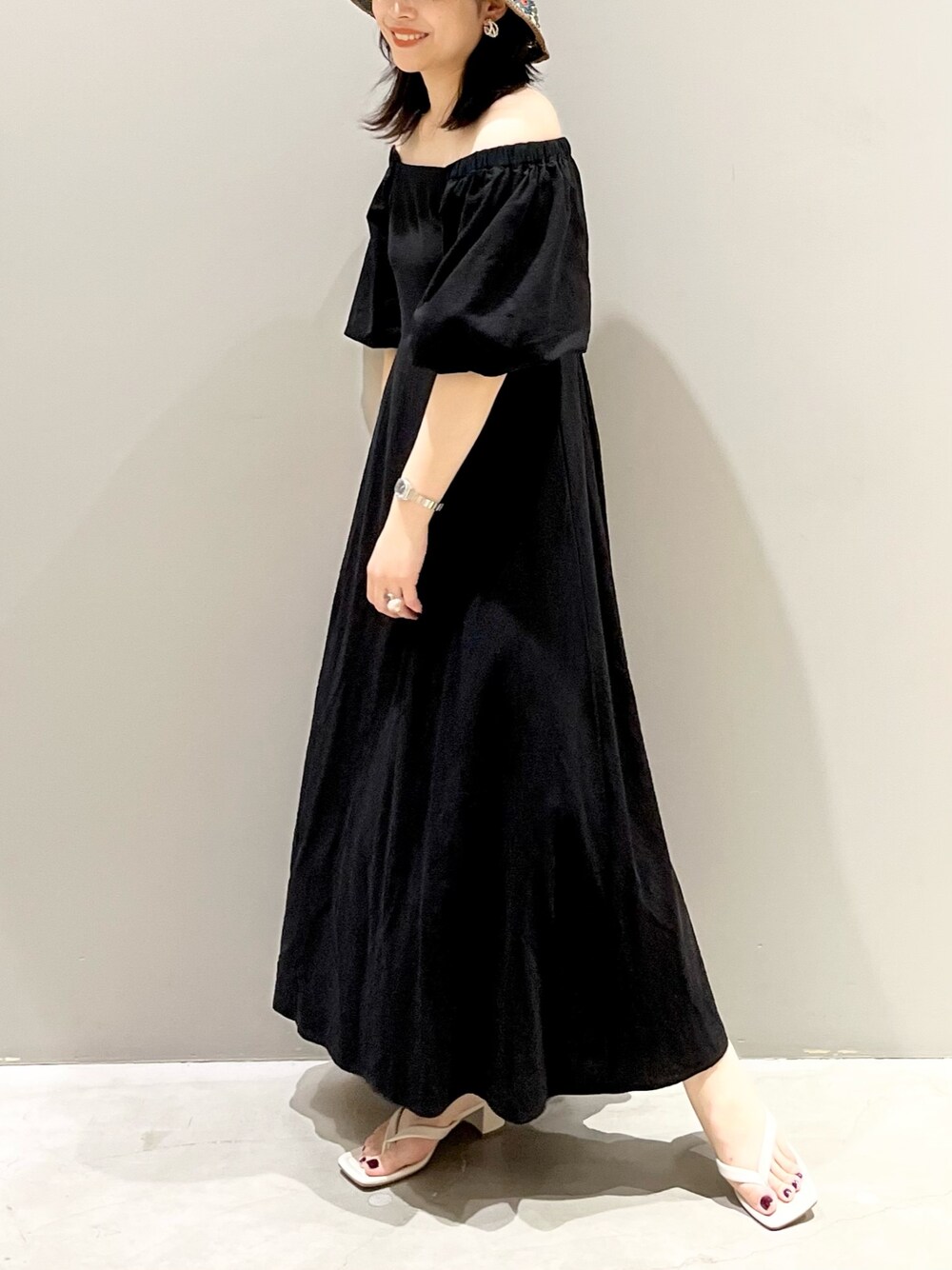 ホワイト系のサンダル、ブラック系のワンピース、その他のハットを着用したレディースの夏コーディネートの1枚目の写真