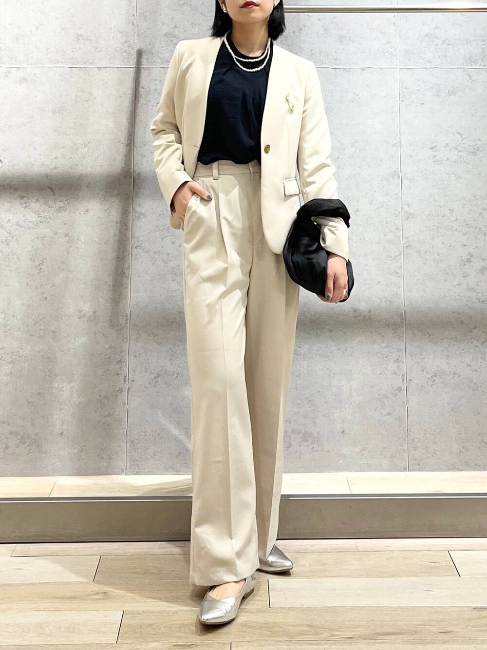 ブラック系のハンドバッグ、ブルー系のシャツ/ブラウス、ホワイト系のノーカラージャケットを着用したレディースの冬コーディネートの1枚目の写真