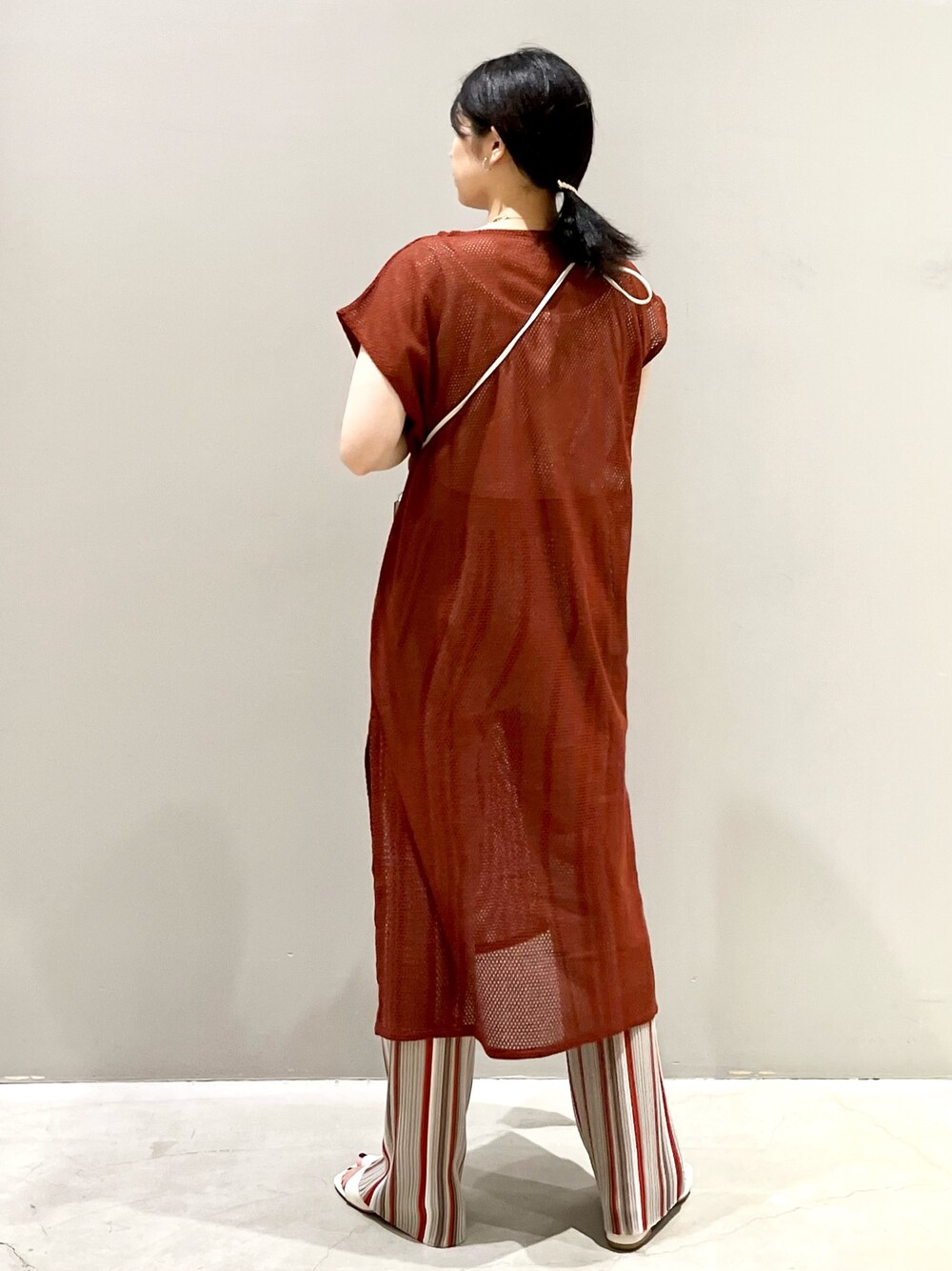 ブラウン系のワンピース、グレー系のパンツ、ホワイト系のサンダルを着用したレディースの秋コーディネートの2枚目の写真