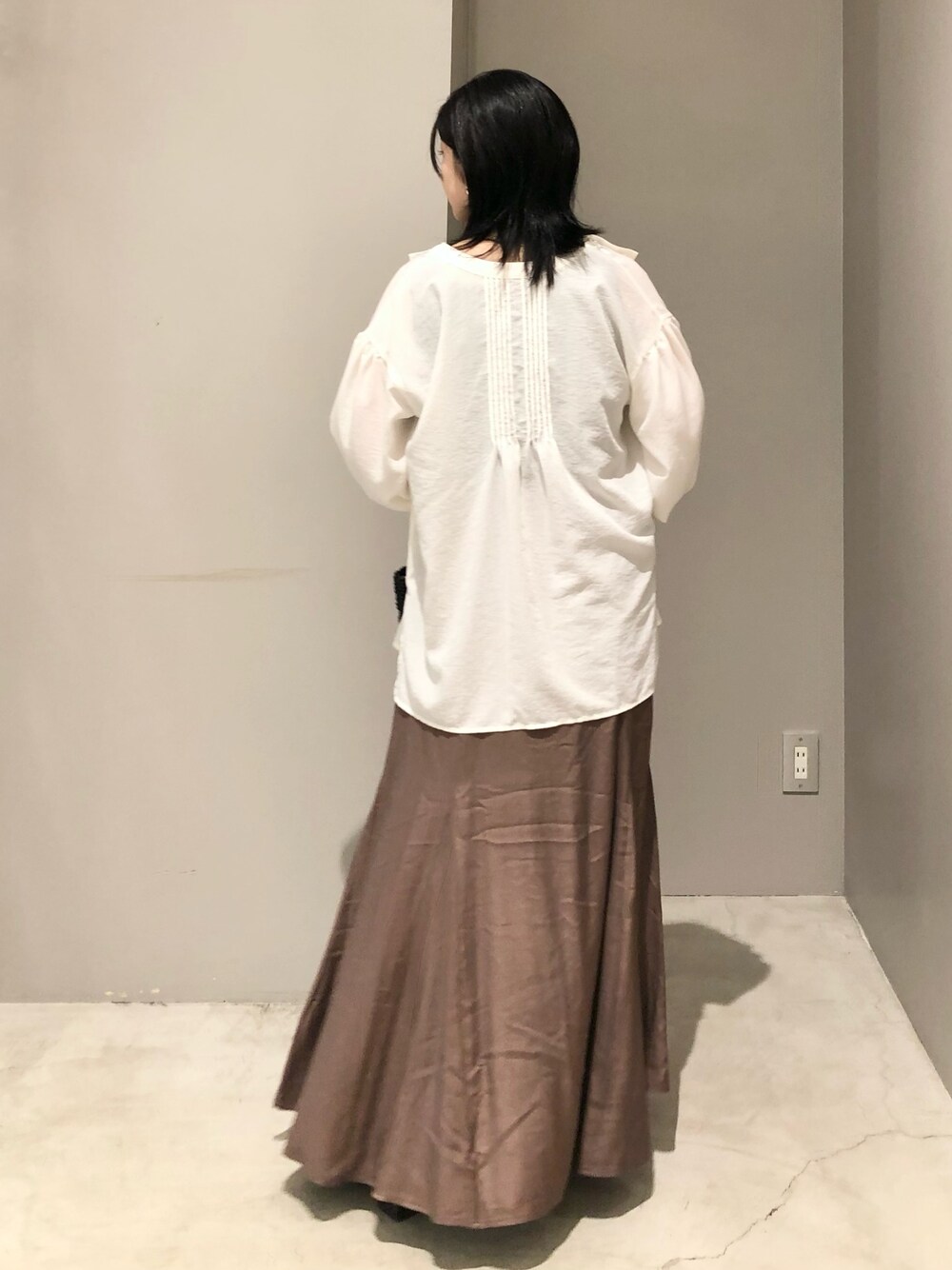 ホワイト系のシャツ/ブラウス、ブラック系のトートバッグ、ブラック系のサンダルを着用したレディースの夏コーディネートの4枚目の写真