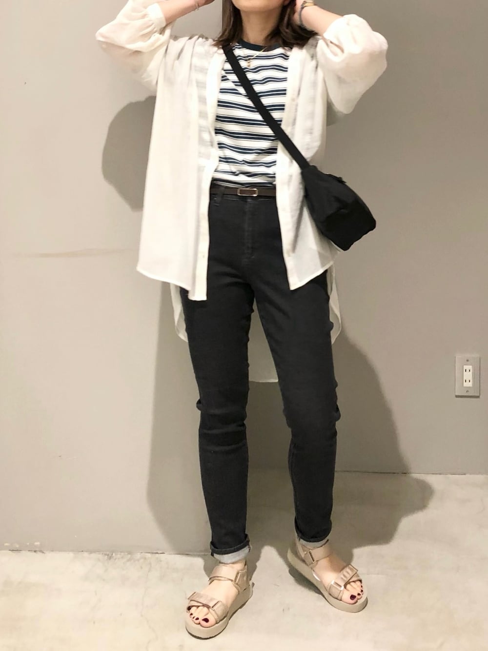 ベージュ系のサンダル、ブラック系のデニムパンツ、グリーン系のTシャツ/カットソーを着用したレディースの春コーディネートの1枚目の写真