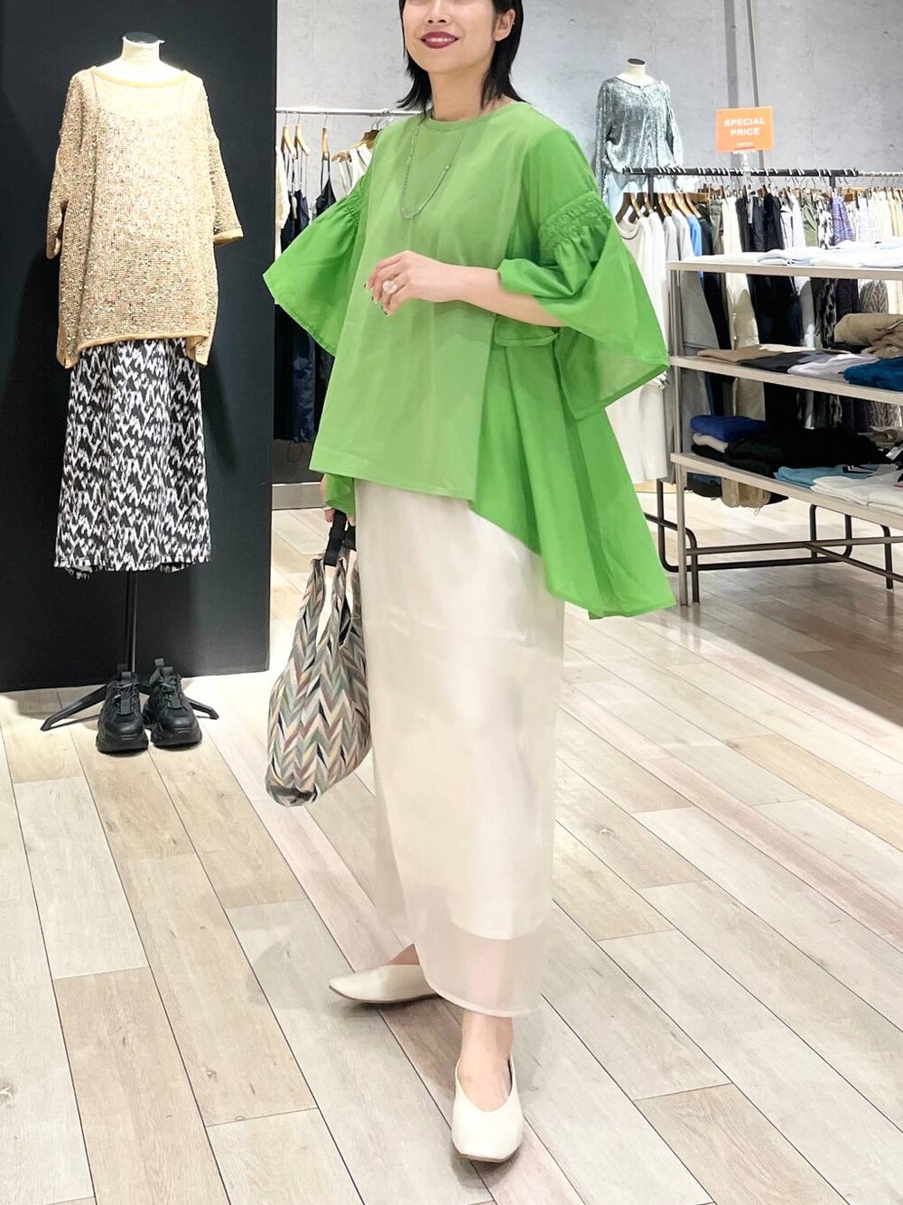 ホワイト系のハンドバッグ、ホワイト系のパンプス、ホワイト系のスカートを着用したレディースの春コーディネートの1枚目の写真