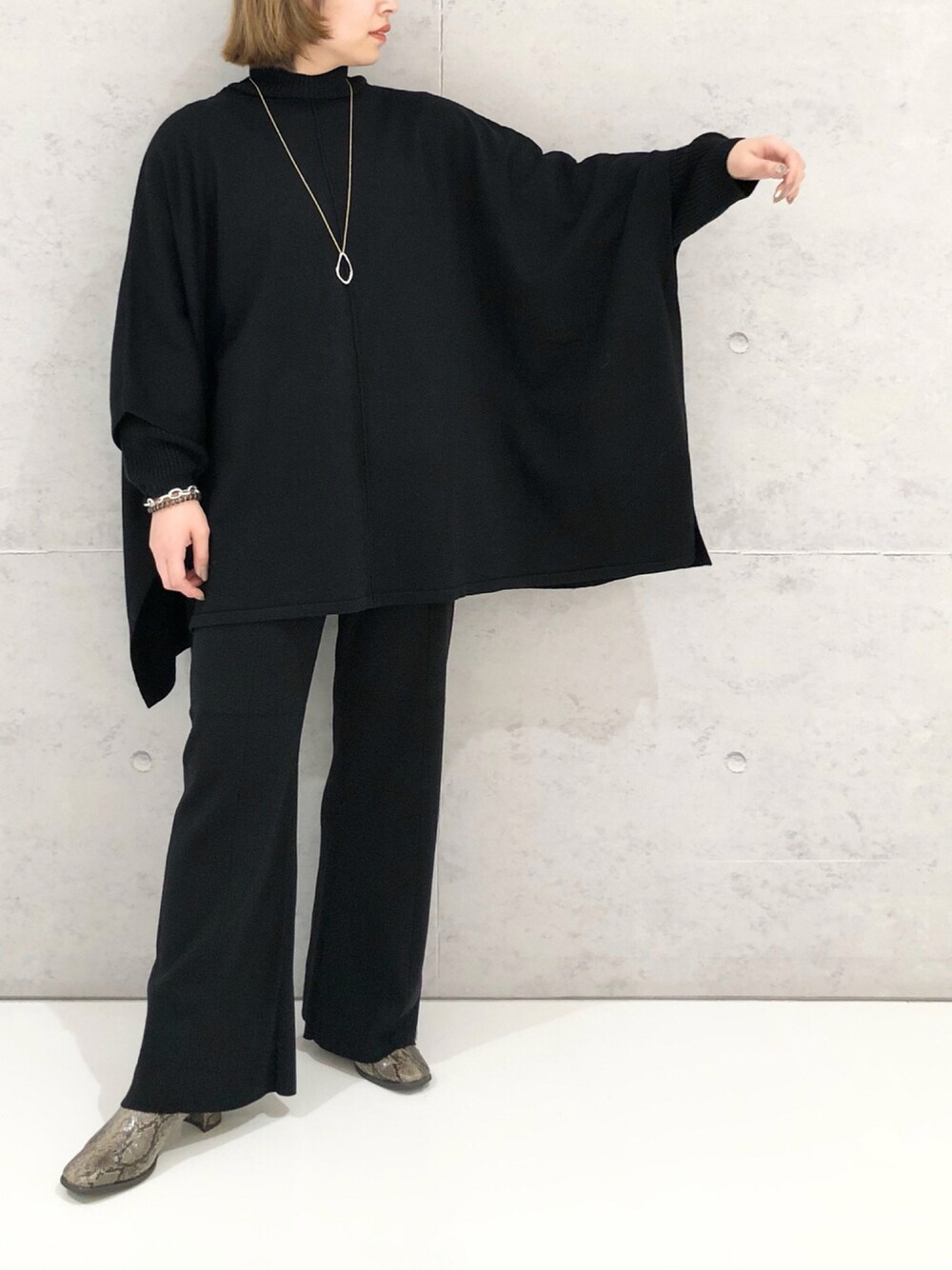 ブラック系のニット/セーター、ブラック系のその他パンツ、その他のブーツを着用したレディースの秋コーディネートの1枚目の写真