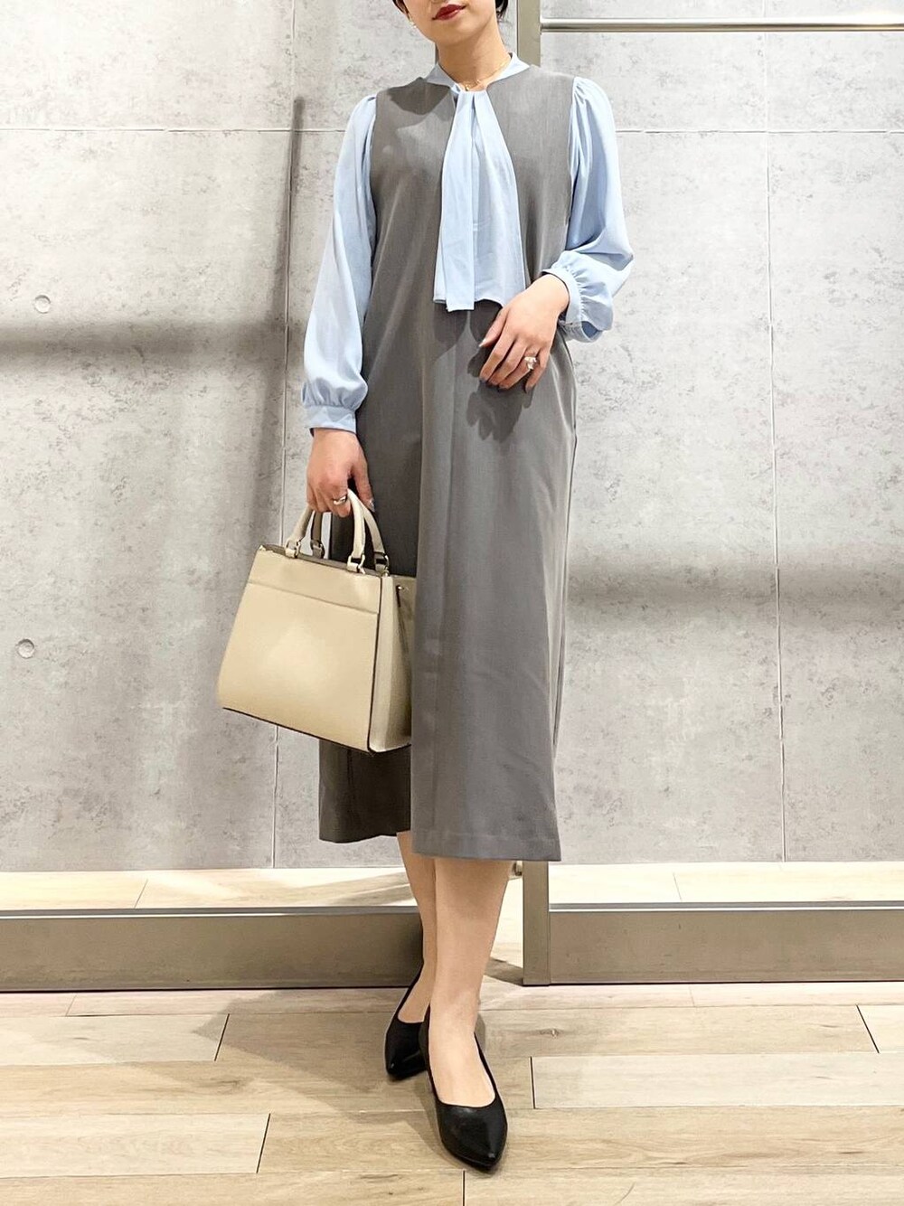 ブルー系のシャツ/ブラウス、ホワイト系のショルダーバッグ、ブラック系のパンプスを着用したレディースの冬コーディネートの1枚目の写真