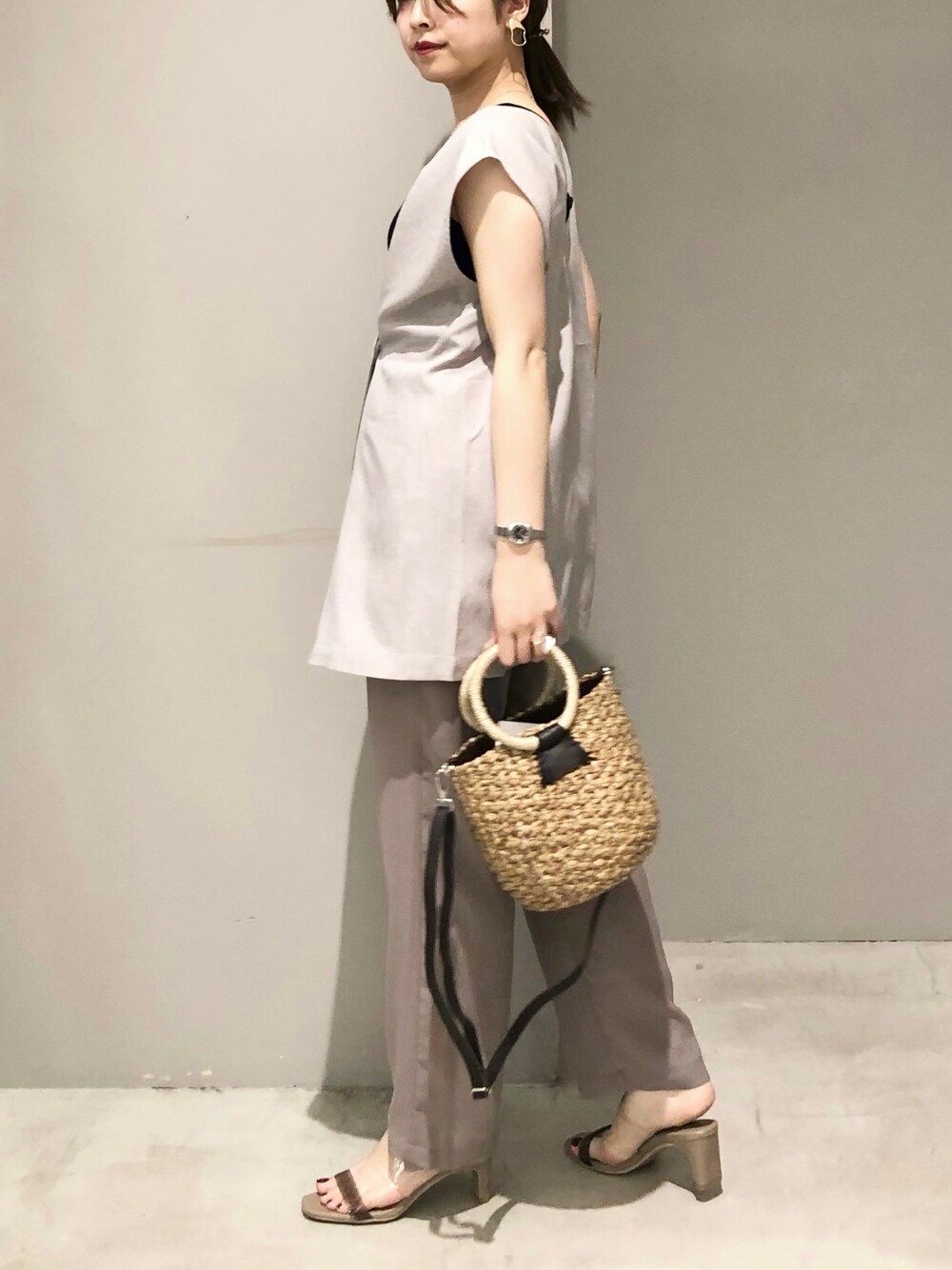 ブラック系のかごバッグ、ベージュ系のサンダル、ブラウン系のその他パンツを着用したレディースの夏コーディネートの3枚目の写真