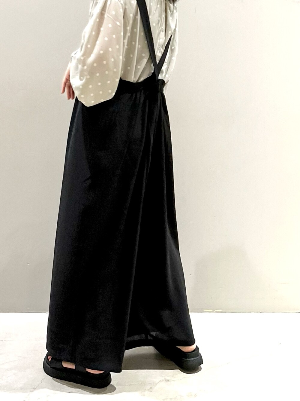 ブラック系のつなぎ/オールインワン、ブラック系のサンダル、ベージュ系のシャツ/ブラウスを着用したレディースの秋コーディネートの3枚目の写真