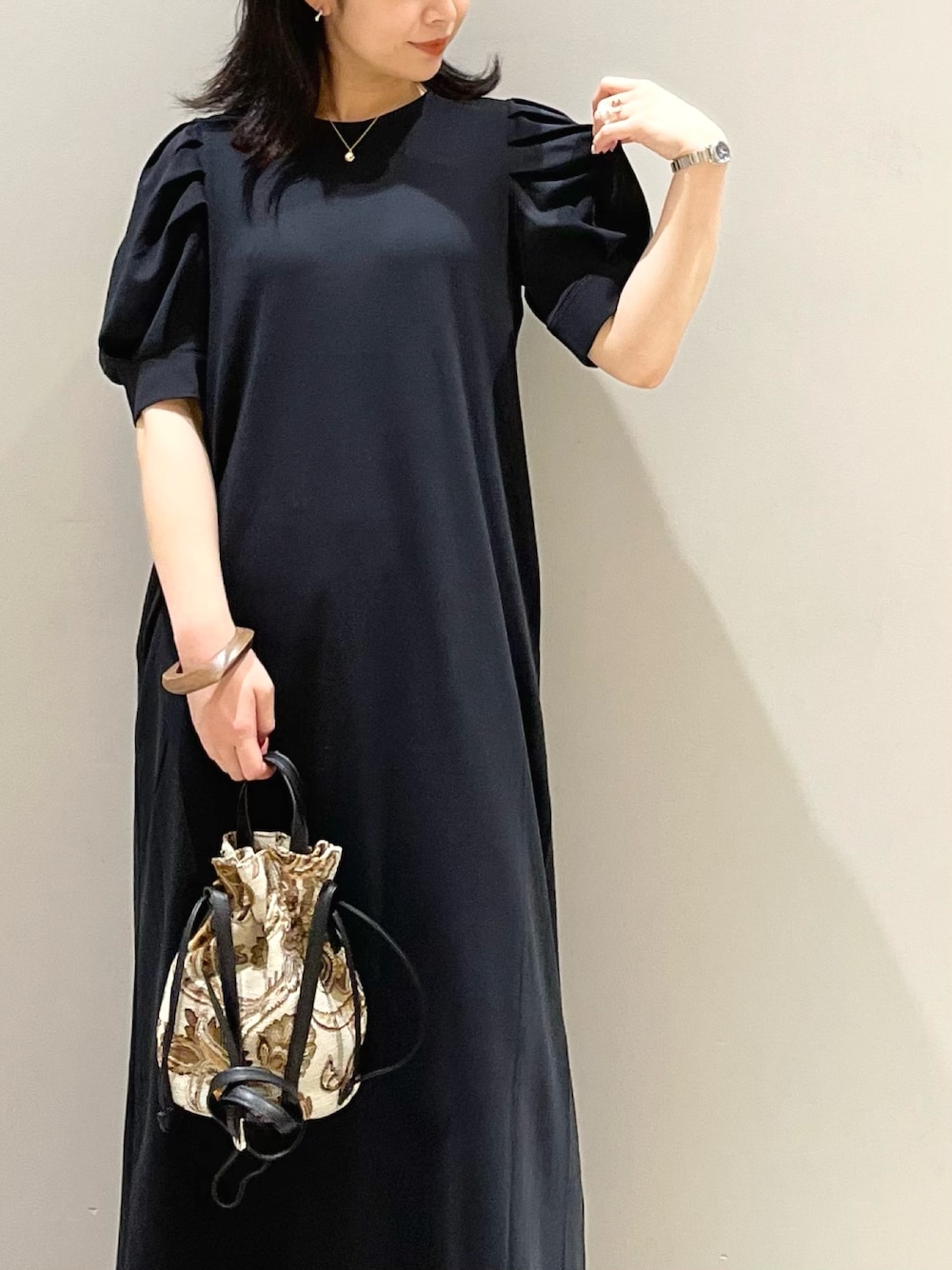 ブラック系のワンピース/ドレス、ホワイト系のサンダル、ブラウン系のショルダーバッグを着用したレディースの夏コーディネートの2枚目の写真