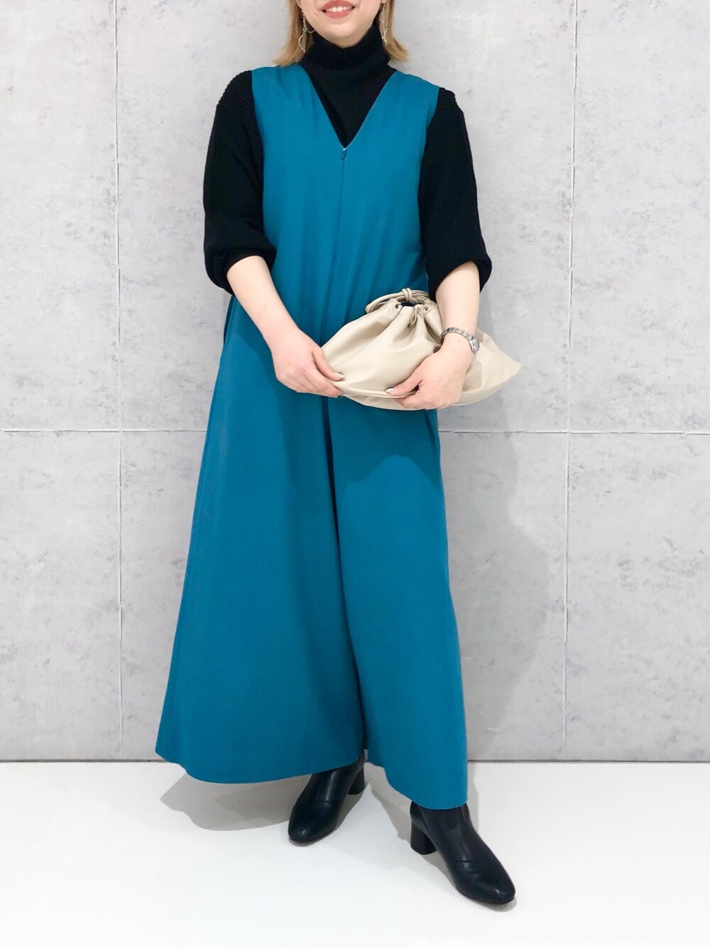 ベージュ系のショルダーバッグ、ブラック系のブーツ、ブルー系のつなぎ/オールインワンを着用したレディースの冬コーディネートの3枚目の写真