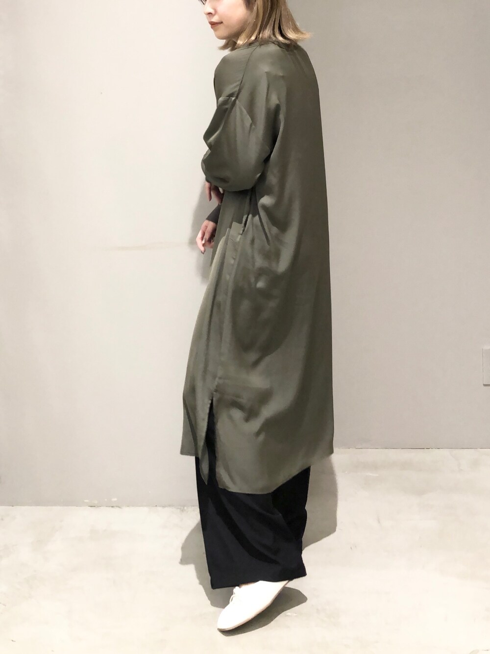 ブラック系のスラックス、ホワイト系のパンプス、グリーン系のマタニティウェア/グッズを着用したレディースの春コーディネートの2枚目の写真