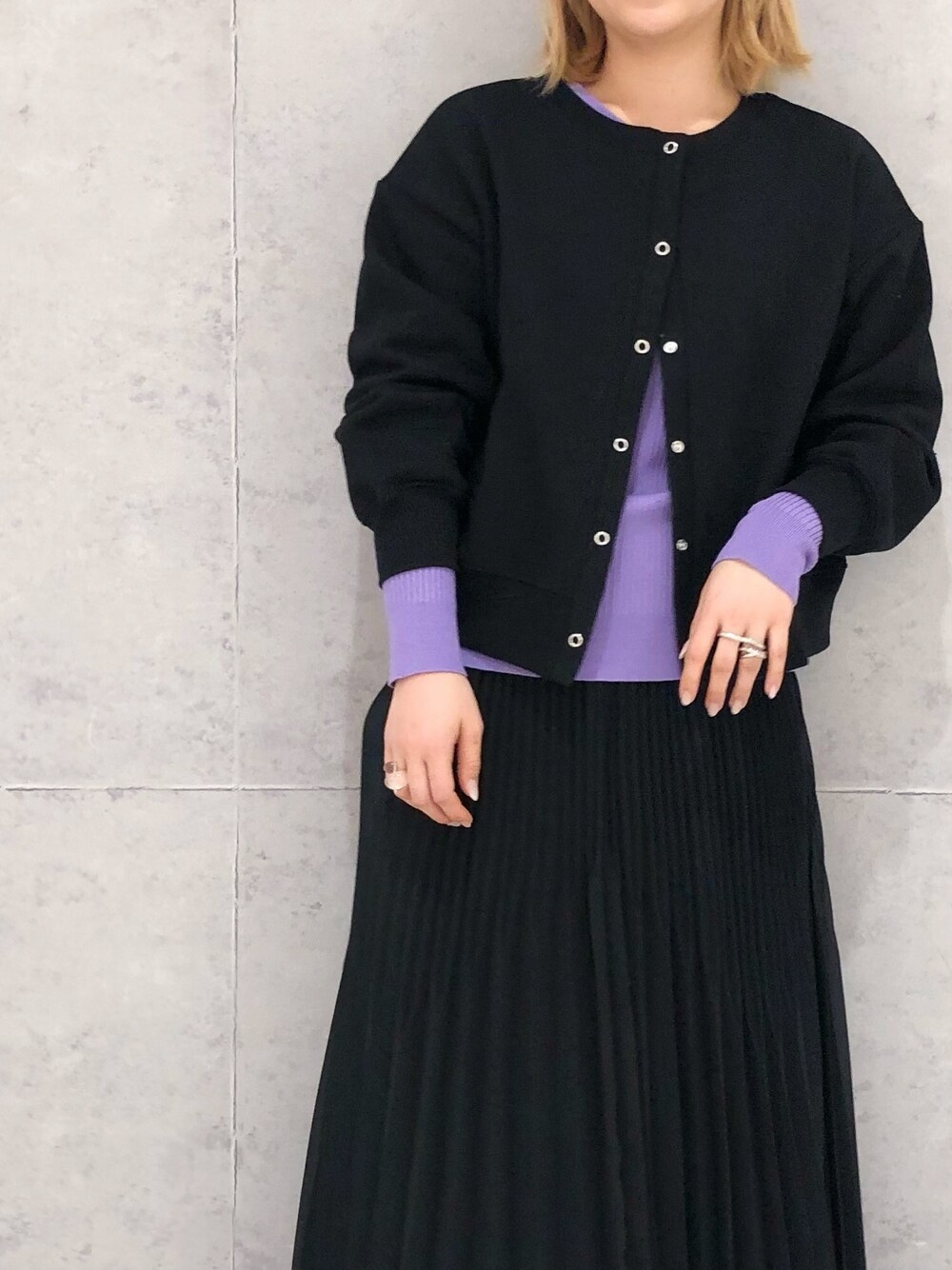 ブラック系のスカート、シルバー系のパンプス、パープル系のニット/セーターを着用したレディースの冬コーディネートの3枚目の写真