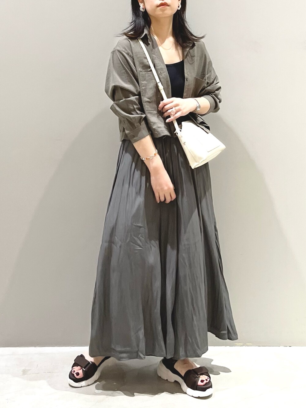 ホワイト系のショルダーバッグ、ブラウン系のサンダル、グレー系のその他パンツを着用したレディースの夏コーディネートの3枚目の写真