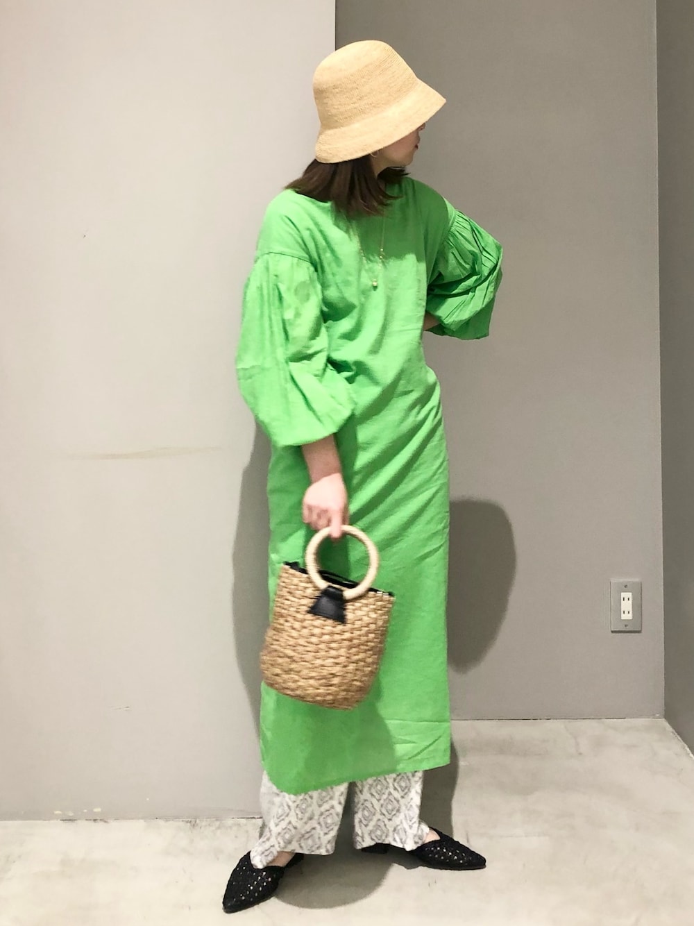 ブラック系のかごバッグ、グレー系のその他パンツ、ブラック系のサンダルを着用したレディースの春コーディネートの2枚目の写真