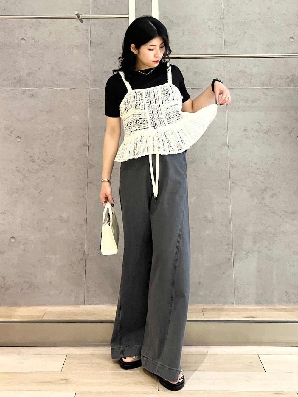 ブラック系のTシャツ/カットソー、シルバー系のサンダル、ブラック系のデニムパンツを着用したレディースの春コーディネートの1枚目の写真