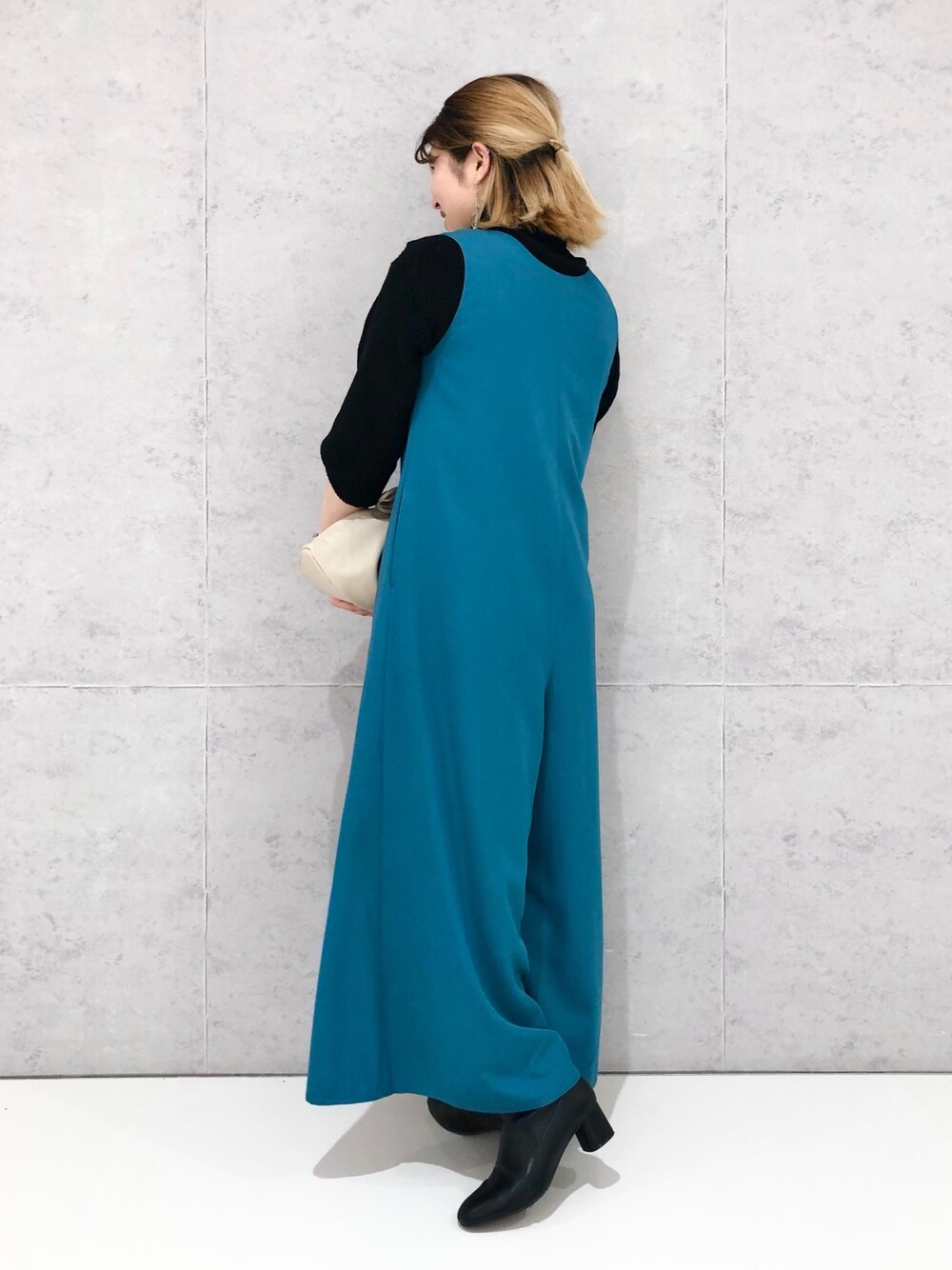 ベージュ系のショルダーバッグ、ブラック系のブーツ、ブルー系のつなぎ/オールインワンを着用したレディースの冬コーディネートの4枚目の写真