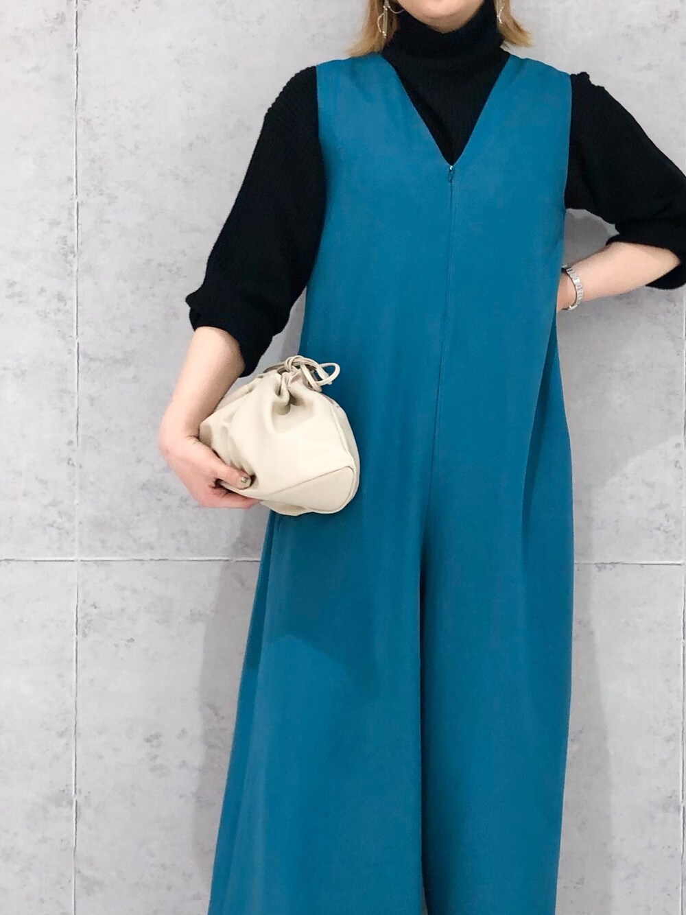 ベージュ系のショルダーバッグ、ブラック系のブーツ、ブルー系のつなぎ/オールインワンを着用したレディースの冬コーディネートの2枚目の写真