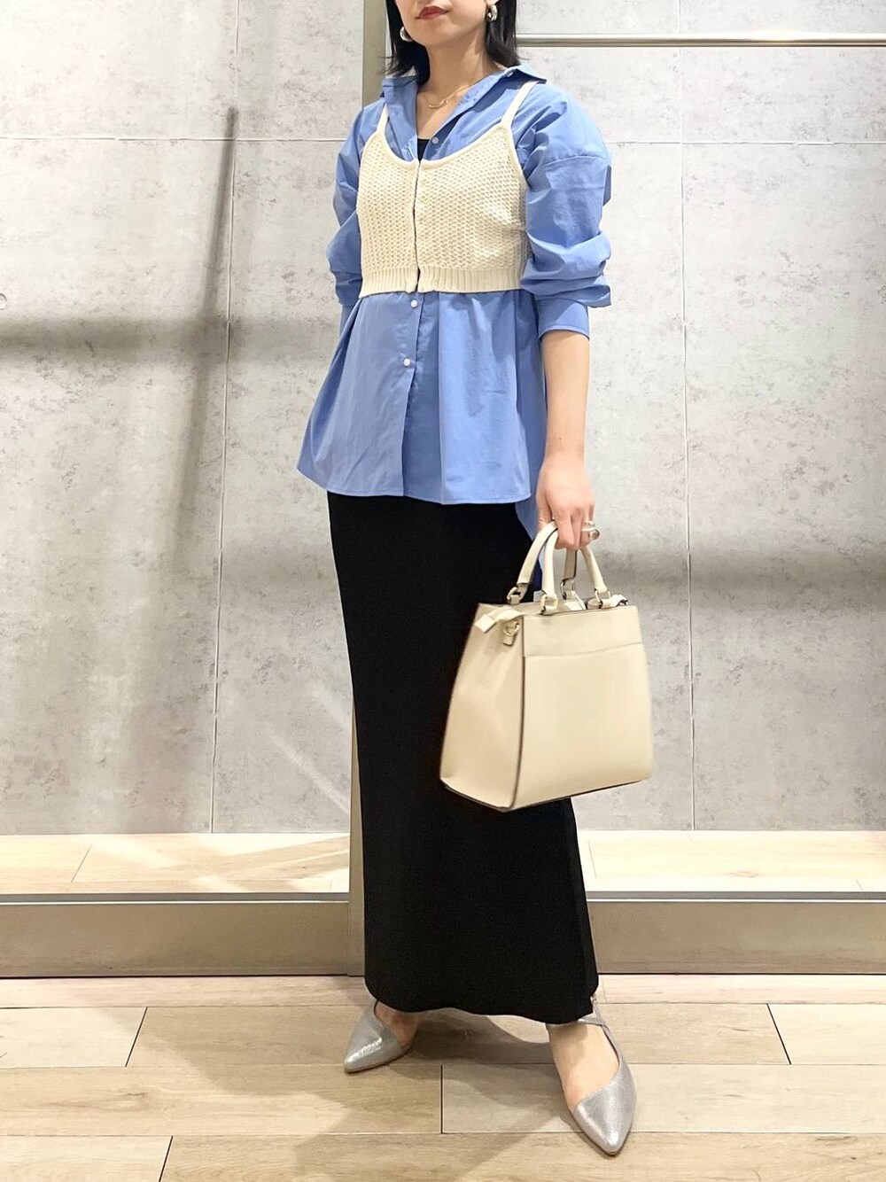 ブルー系のシャツ/ブラウス、ブラック系のスカート、ホワイト系のショルダーバッグを着用したレディースの冬コーディネートの1枚目の写真