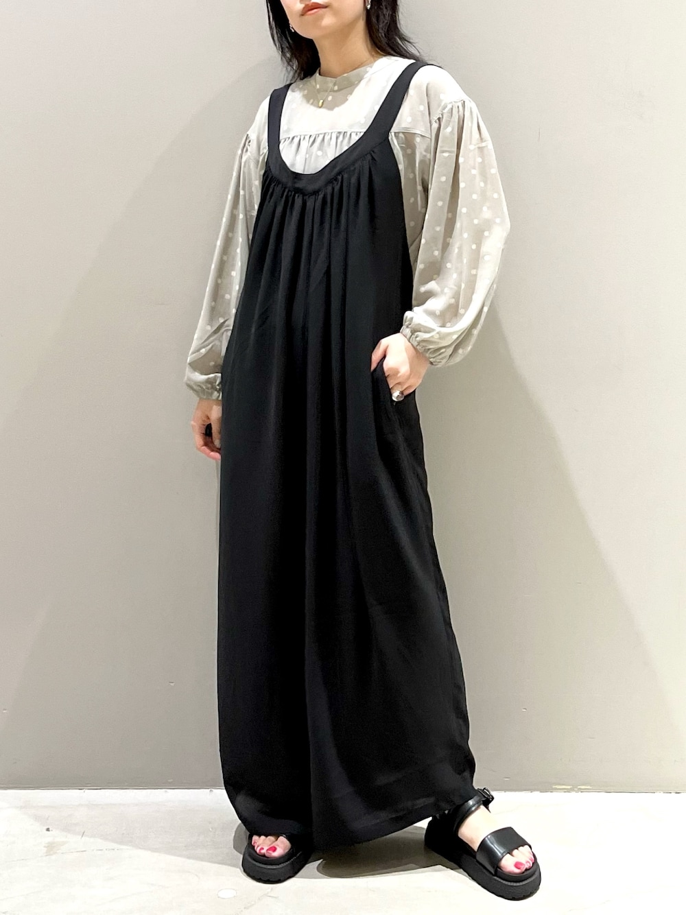 ブラック系のつなぎ/オールインワン、ブラック系のサンダル、ベージュ系のシャツ/ブラウスを着用したレディースの秋コーディネートの2枚目の写真