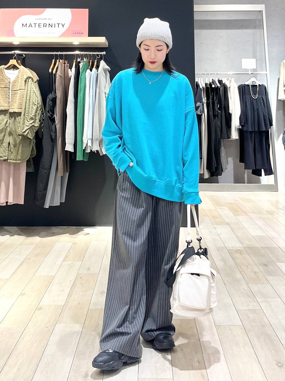 ホワイト系のショルダーバッグ、グレー系のその他パンツ、ブラック系のスニーカーを着用したレディースの冬コーディネートの1枚目の写真