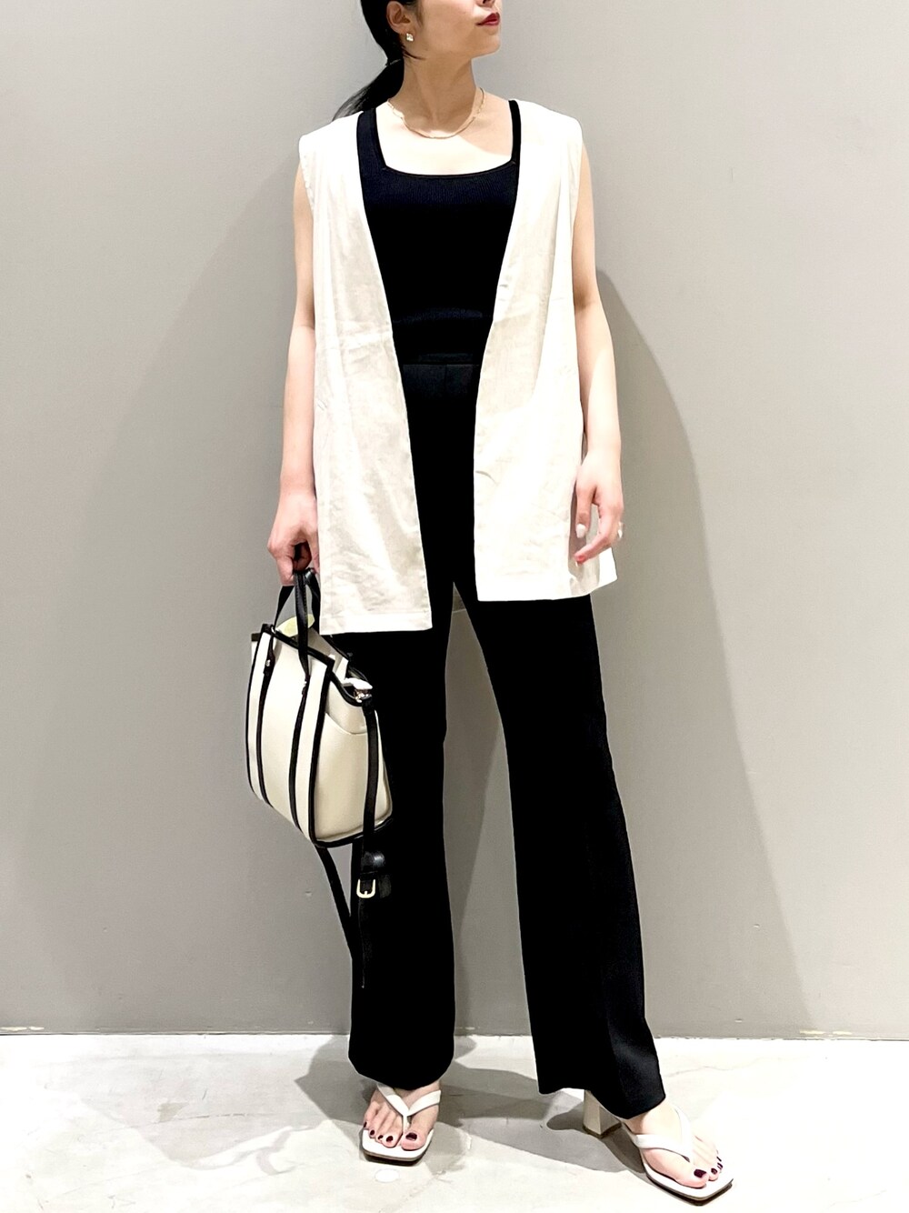 ホワイト系のベスト、ブラック系のタンクトップ、ブラック系のその他パンツを着用したレディースの秋コーディネートの2枚目の写真