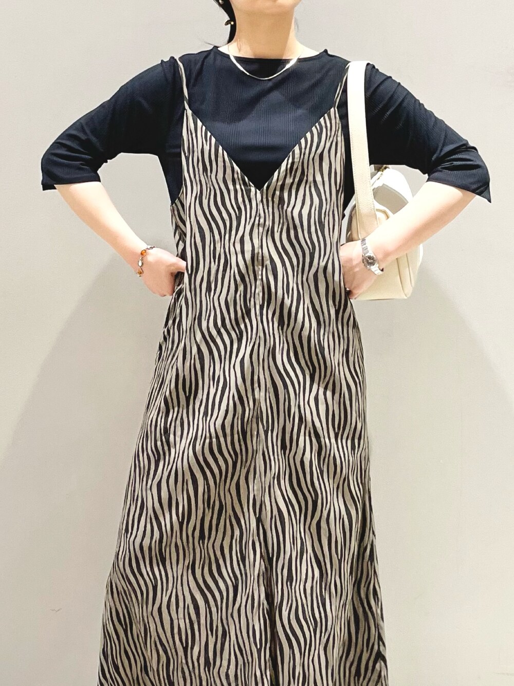 ホワイト系のサンダル、ホワイト系のショルダーバッグ、ブラック系のワンピース/ドレスを着用したレディースの秋コーディネートの4枚目の写真