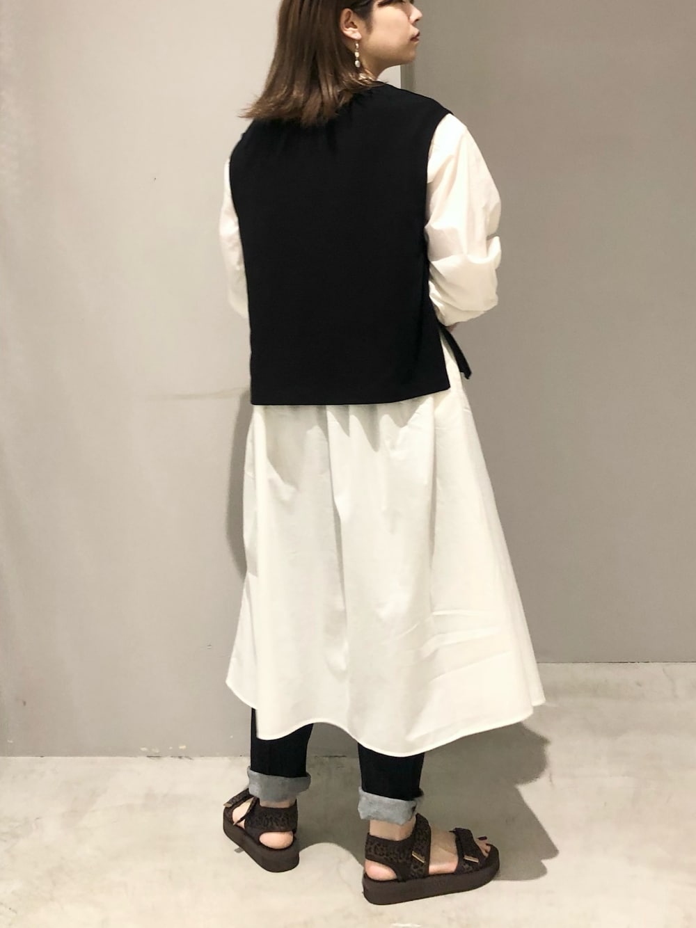 グリーン系のショルダーバッグ、ホワイト系のワンピース、その他のサンダルを着用したレディースの夏コーディネートの3枚目の写真