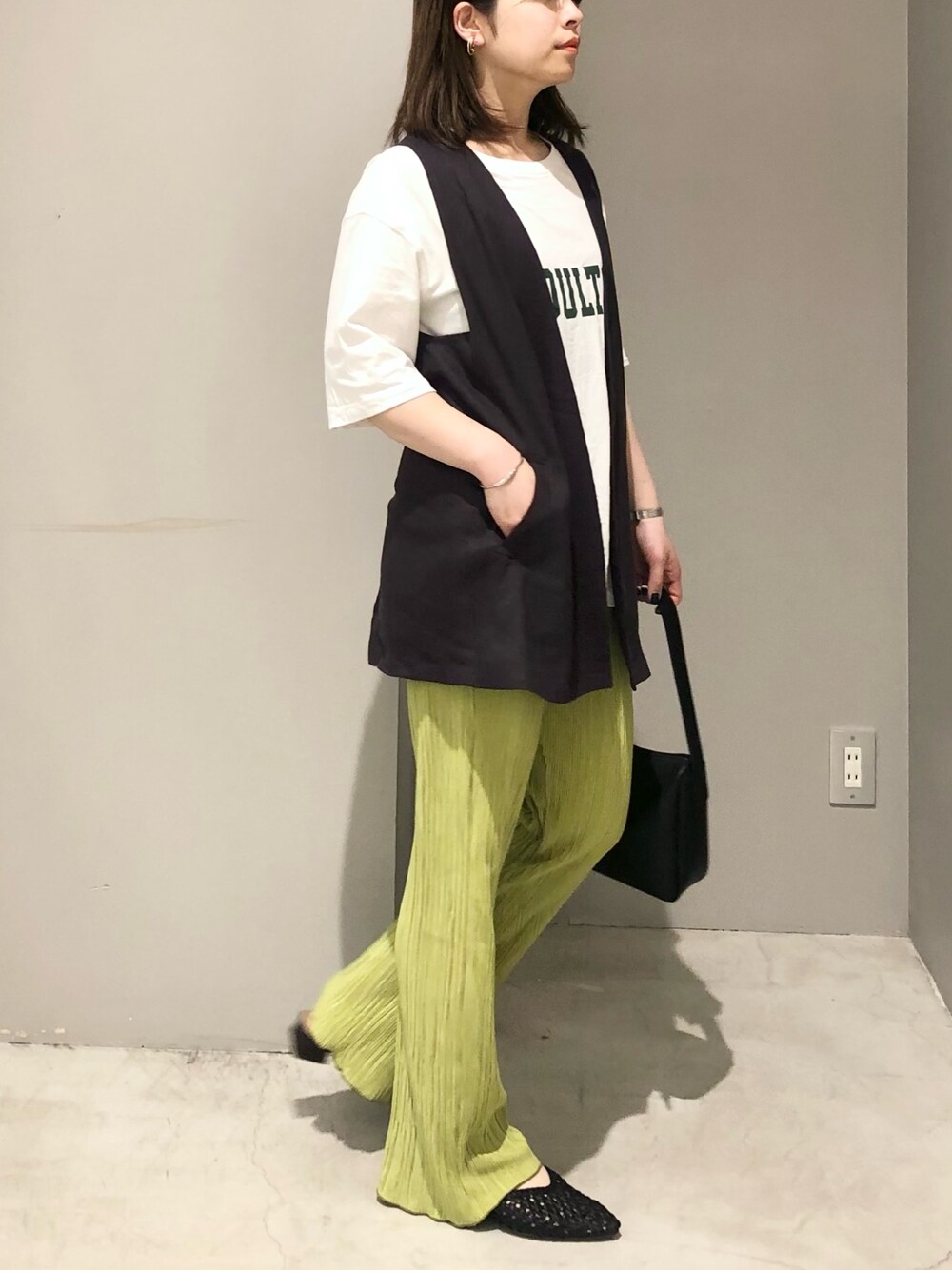 ホワイト系のTシャツ/カットソー、グレー系のベスト、グリーン系のその他パンツを着用したレディースの春コーディネートの1枚目の写真