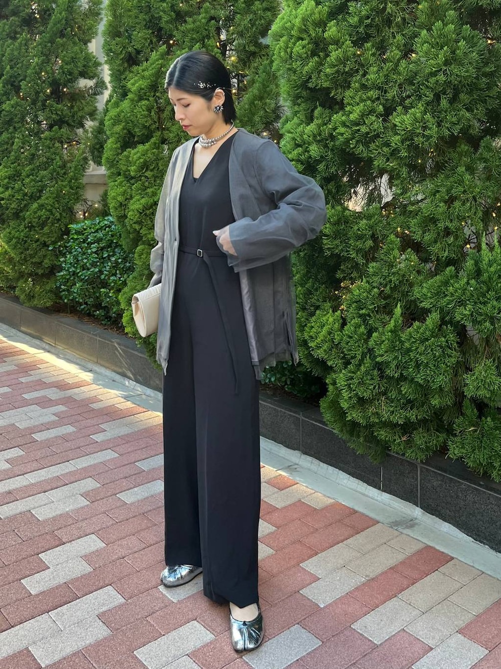 グレー系のノーカラージャケット、ブラック系のつなぎ/オールインワン、シルバー系のネックレスを着用したレディースの秋コーディネートの1枚目の写真