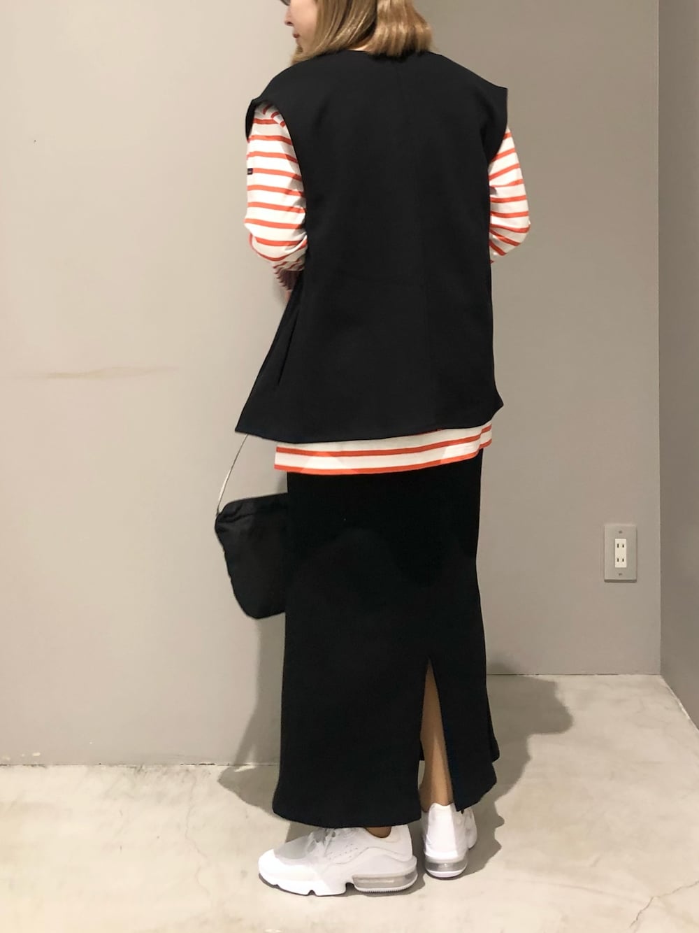 ホワイト系のシューズ、ブラック系のショルダーバッグ、ブラック系のスカートを着用したレディースの春コーディネートの2枚目の写真