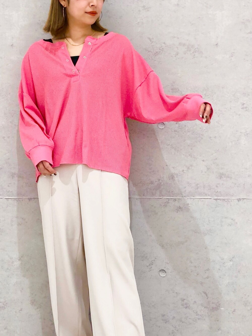 ベージュ系のスラックス、ブラック系のパンプス、ブラック系のタンクトップを着用したレディースの冬コーディネートの2枚目の写真