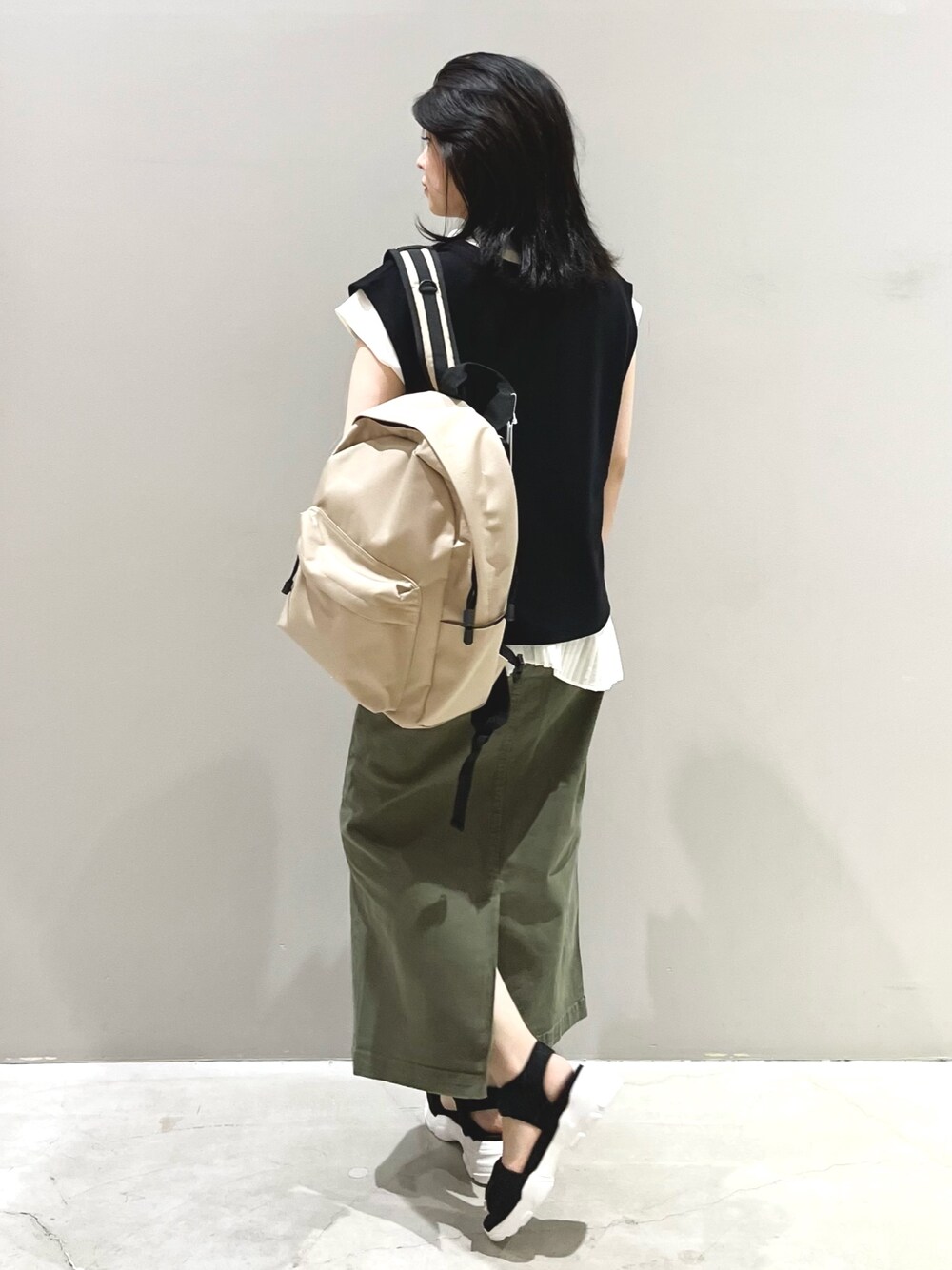 ブラック系のベスト、ホワイト系のシャツ/ブラウス、グリーン系のスカートを着用したレディースの夏コーディネートの4枚目の写真