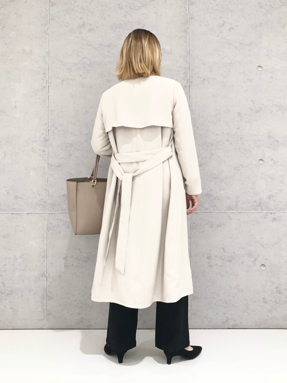 ホワイト系のニット/セーター、ベージュ系のトレンチコート、ブルー系のその他パンツを着用したレディースの冬コーディネートの3枚目の写真