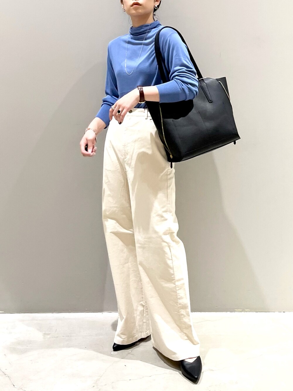 ホワイト系のパンツ、ブラック系のパンプス、ブラック系のトートバッグを着用したレディースの秋コーディネートの1枚目の写真