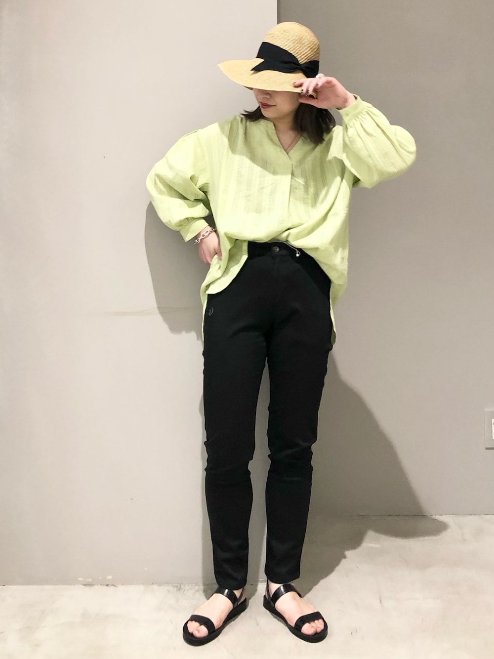 イエロー系のシャツ/ブラウス、ブラック系のパンツ、ブラック系のサンダルを着用したレディースの春コーディネートの1枚目の写真