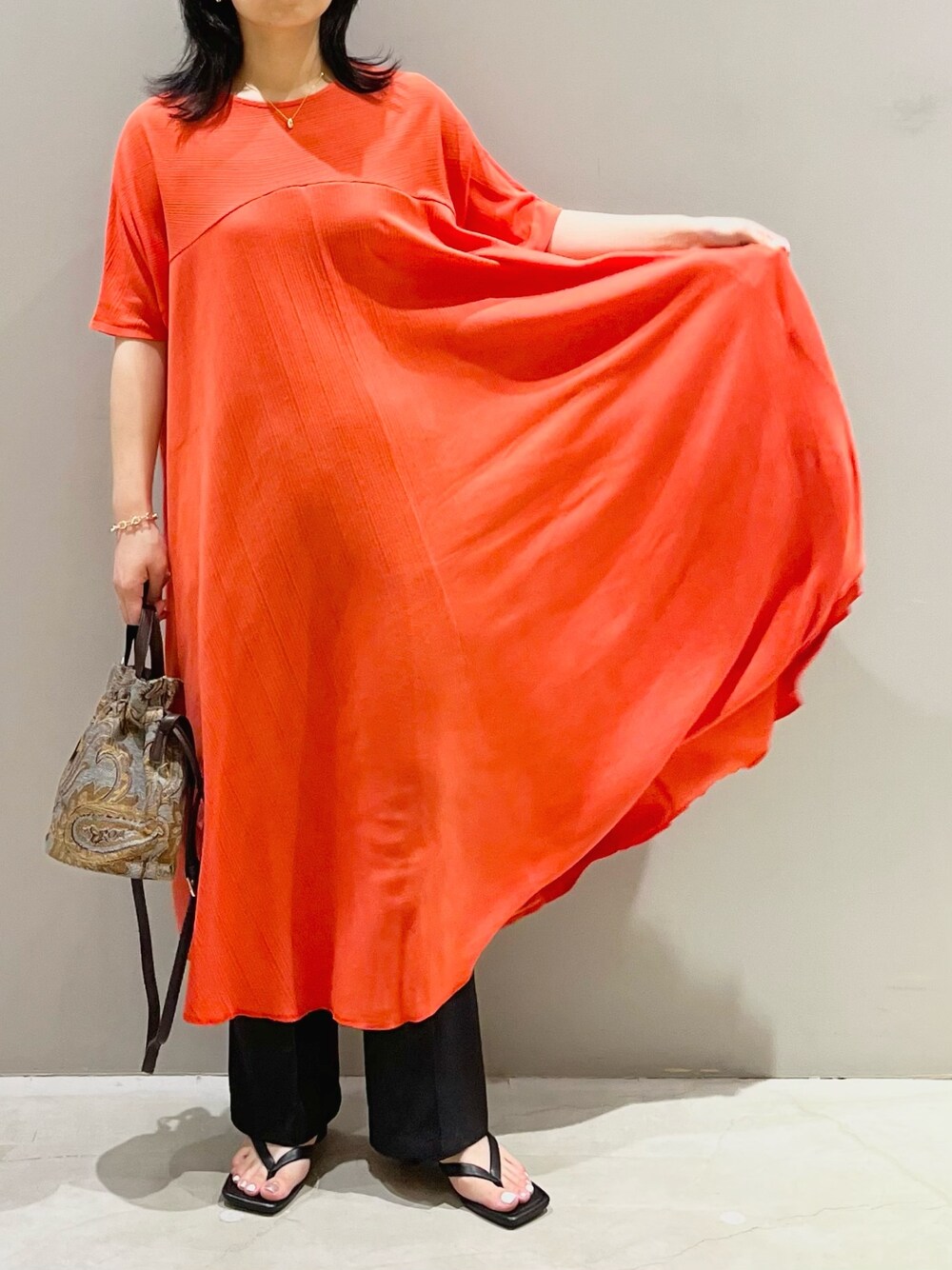 レッド系のワンピース、ブルー系のショルダーバッグ、ブラック系のサンダルを着用したレディースの夏コーディネートの4枚目の写真