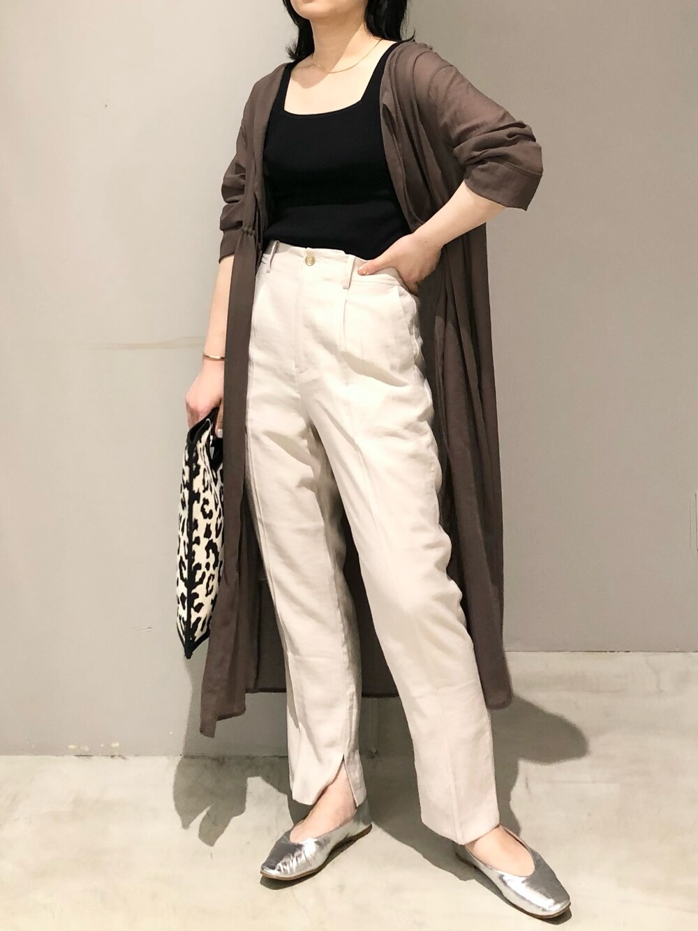 その他のトートバッグ、シルバー系のパンプス、ベージュ系のスラックスを着用したレディースの夏コーディネートの2枚目の写真