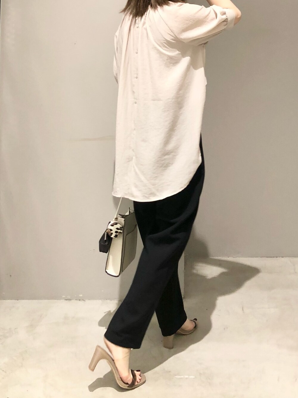 ブラック系のその他パンツ、ベージュ系のサンダル、ホワイト系のショルダーバッグを着用したレディースの夏コーディネートの2枚目の写真