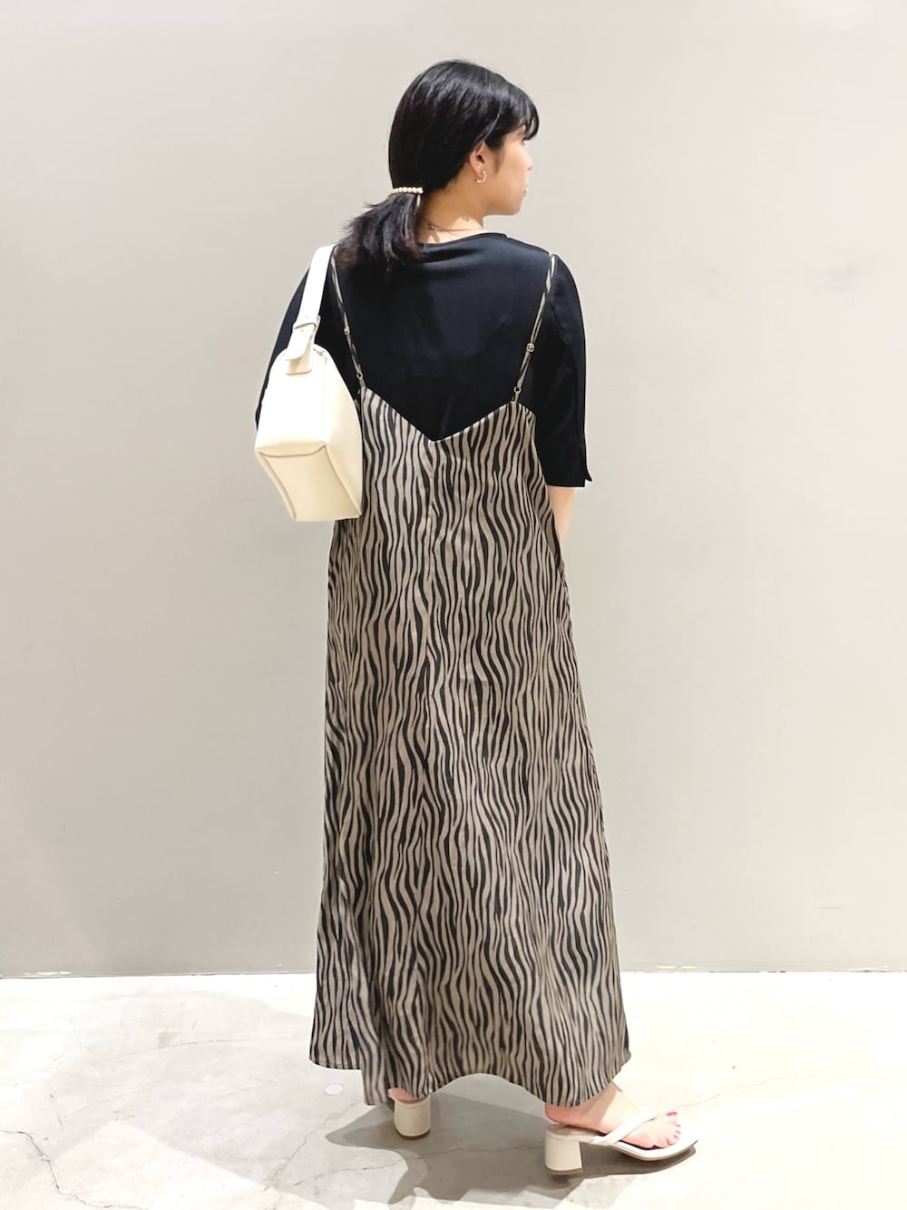 ホワイト系のサンダル、ホワイト系のショルダーバッグ、ブラック系のワンピース/ドレスを着用したレディースの秋コーディネートの2枚目の写真