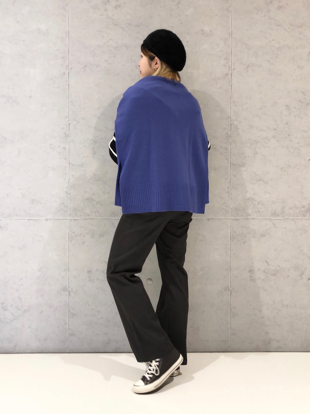 グレー系のチノパンツ、グレー系のスニーカー、ブラック系のニット/セーターを着用したレディースの冬コーディネートの3枚目の写真