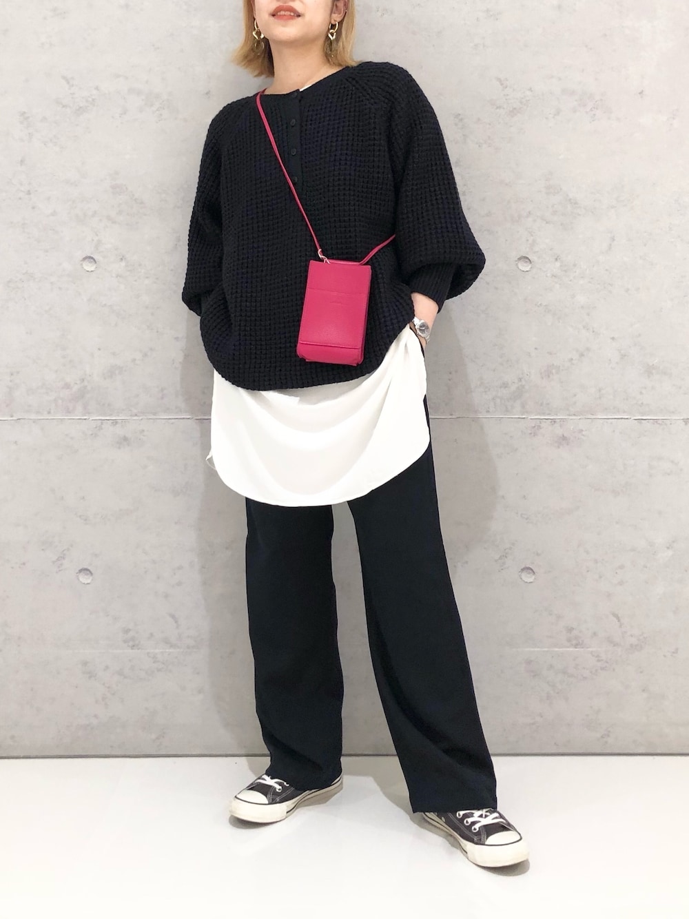 ホワイト系のシャツ/ブラウス、ブルー系のニット/セーター、レッド系のパンツを着用したレディースの冬コーディネートの1枚目の写真