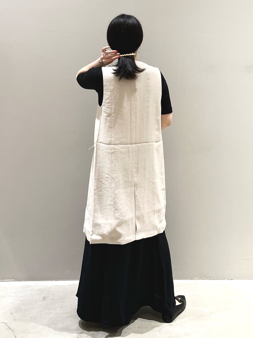 ブラウン系のショルダーバッグ、ブラック系のローファー、ブラック系のスカートを着用したレディースの夏コーディネートの3枚目の写真