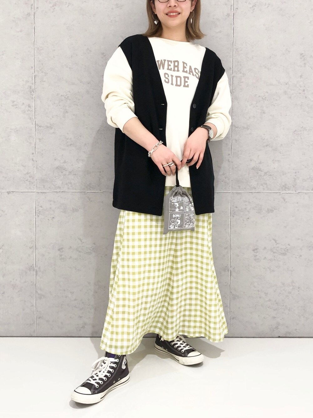 ホワイト系のスウェット、ブラック系のトップス、イエロー系のスカートを着用したレディースの冬コーディネートの2枚目の写真