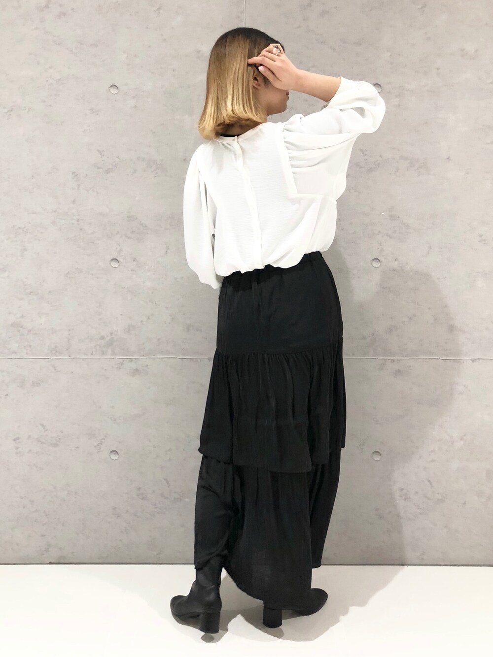 ホワイト系のシャツ/ブラウス、グリーン系のニット/セーター、ブラック系のスカートを着用したレディースの春コーディネートの3枚目の写真