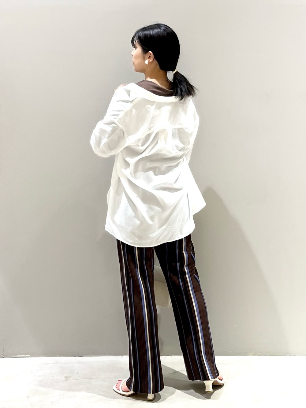 ホワイト系のショルダーバッグ、ホワイト系のサンダル、ブラウン系のその他パンツを着用したレディースの秋コーディネートの3枚目の写真