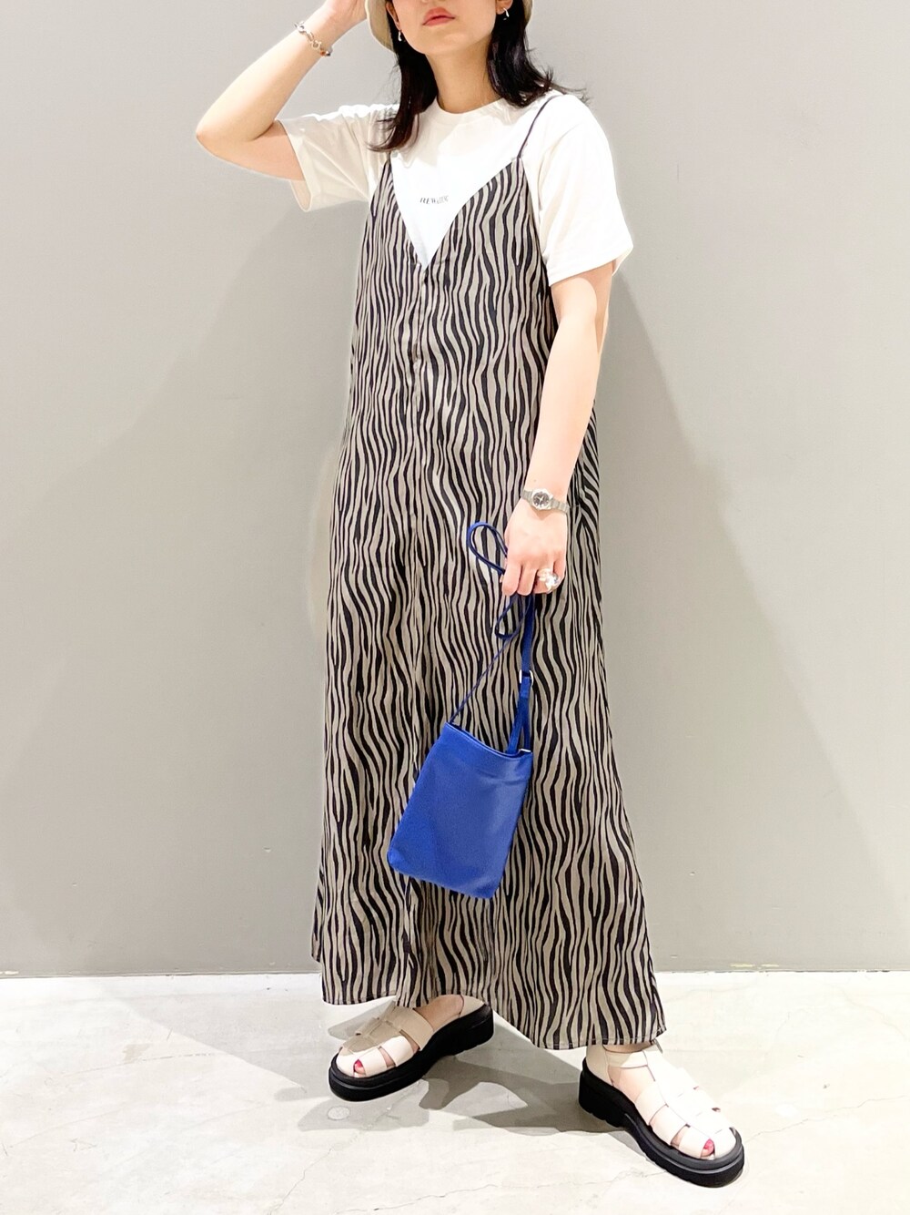 ブラウン系のワンピース、ブルー系のバッグ、ホワイト系のTシャツ/カットソーを着用したレディースの夏コーディネートの3枚目の写真