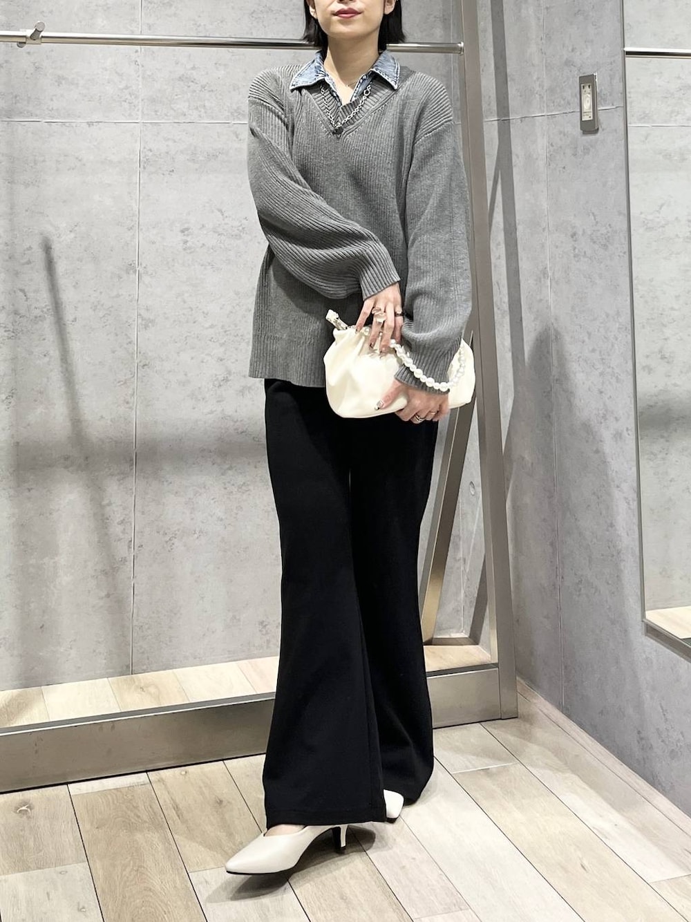 ホワイト系のパンプス、ホワイト系のショルダーバッグ、ブラック系のその他パンツを着用したレディースの冬コーディネートの1枚目の写真