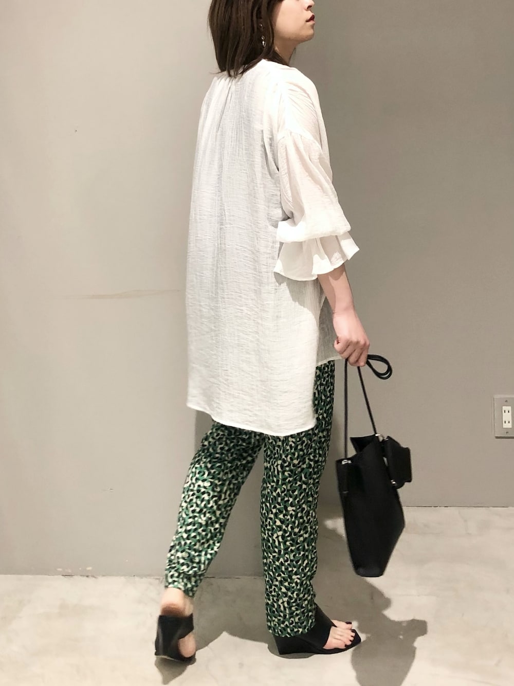 ブラック系のサンダル、グリーン系のその他パンツ、ブラック系のバッグを着用したレディースの夏コーディネートの2枚目の写真