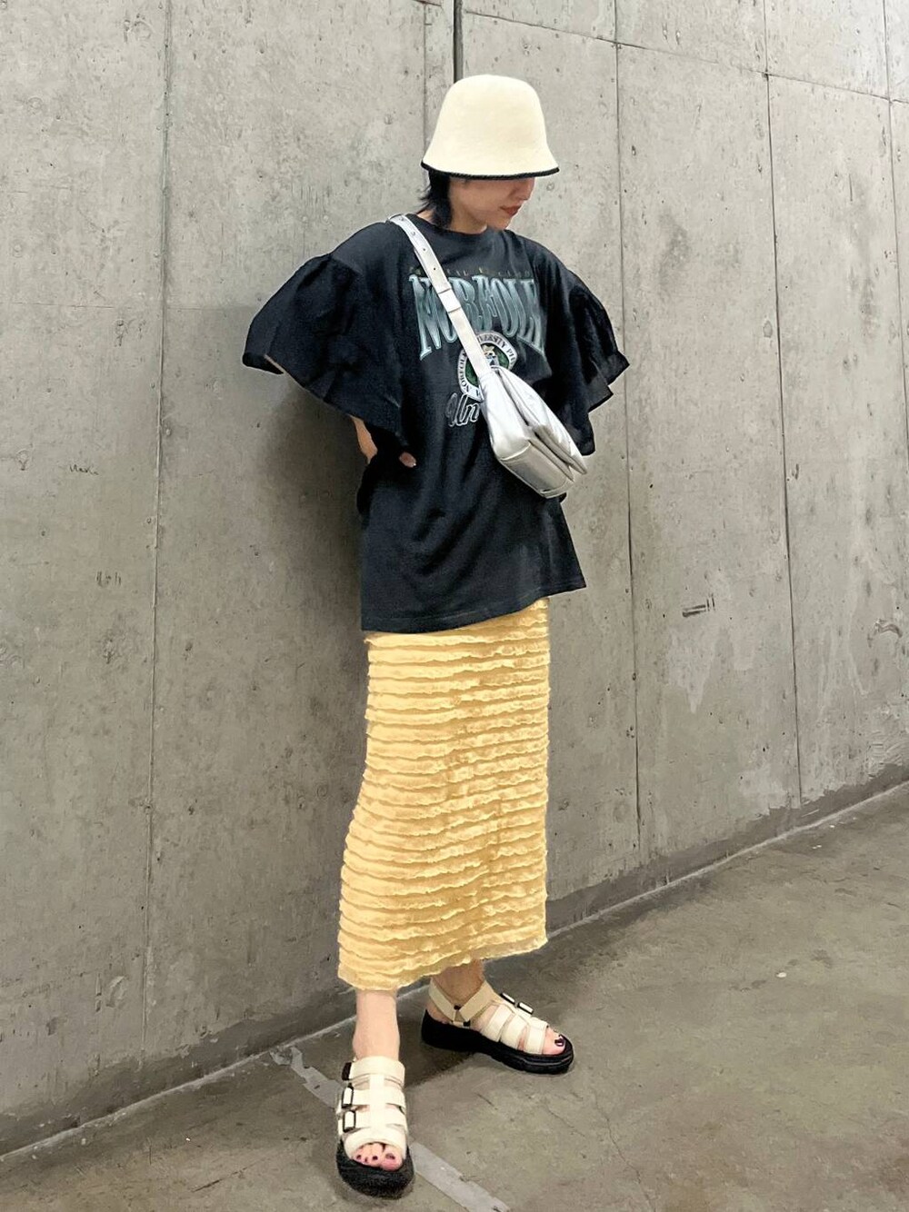 ベージュ系のスカート、シルバー系のショルダーバッグ、ホワイト系のサンダルを着用したレディースの春コーディネートの1枚目の写真