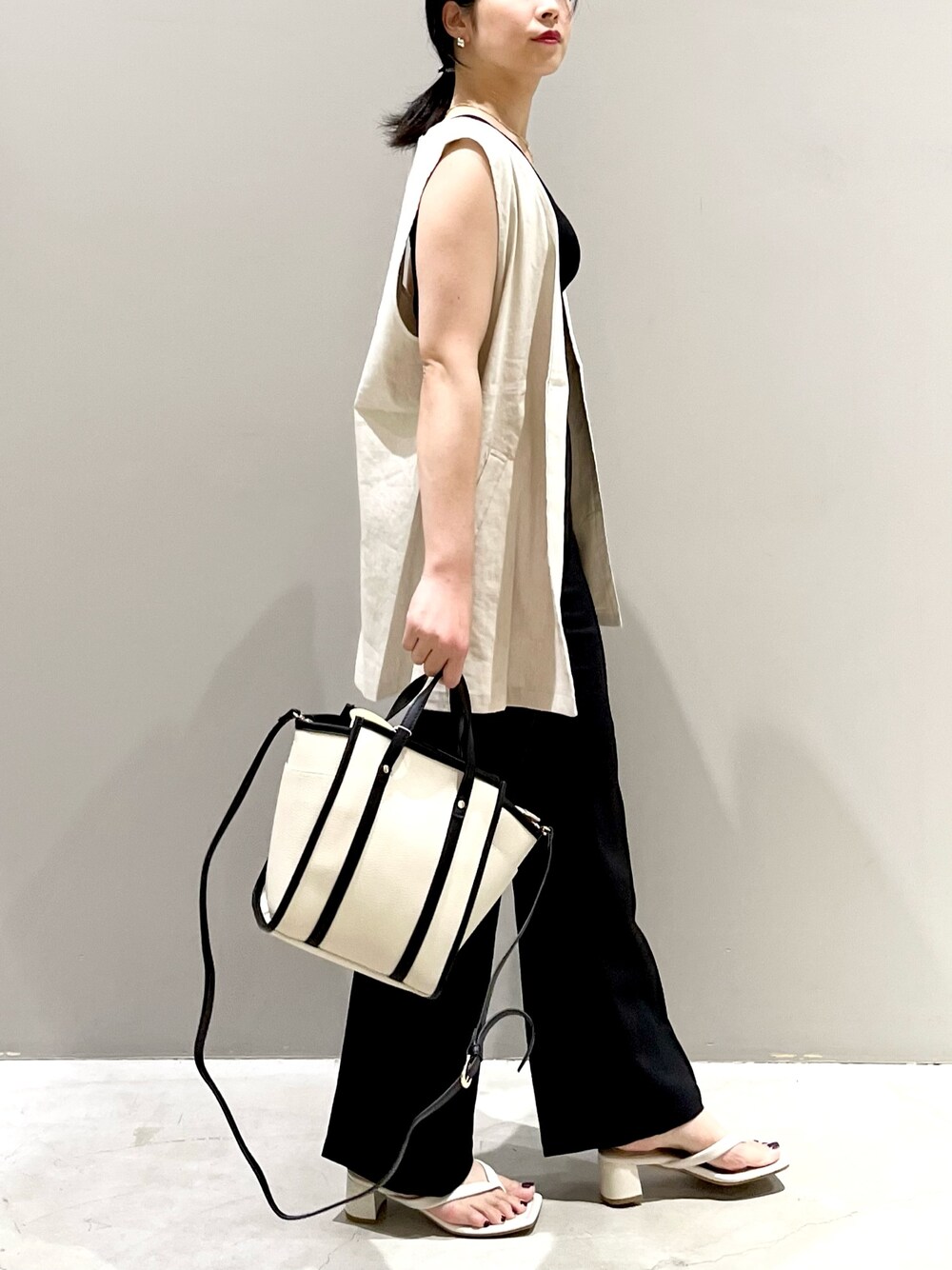 ホワイト系のベスト、ブラック系のタンクトップ、ブラック系のその他パンツを着用したレディースの秋コーディネートの4枚目の写真