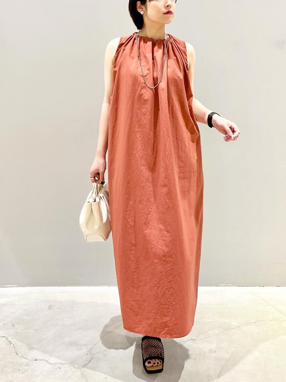 ブラウン系のワンピース、ホワイト系のバッグ、ブラック系のサンダルを着用したレディースの夏コーディネートの1枚目の写真