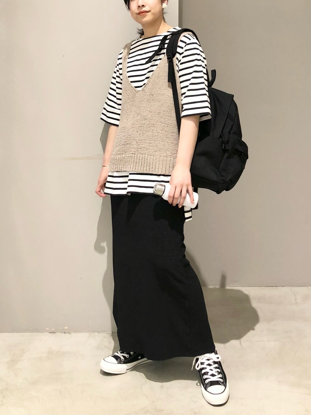 ブラック系のスニーカー、ブラック系のスカート、ブラック系のバックパック/リュックを着用したレディースの夏コーディネートの2枚目の写真
